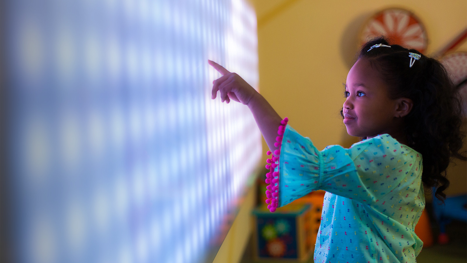 Little girl plays with light-up board